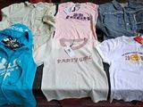 a lot of t - shirts that are sitting on a table