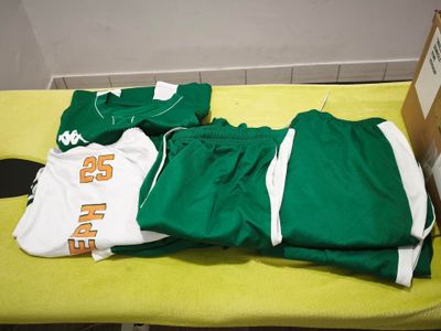 un maillot et un pantalon verts et blancs posés sur une table jaune