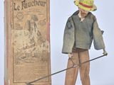 une figurine représentant un homme muni d'un bâton et d'un livre