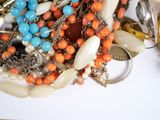 a pile of assorted jewelry on a white surface