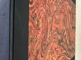 une image représentant un livre à la couverture rouge et noire