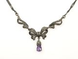 un collier orné d'un améthyste et d'une pierre violette