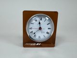 a small clock with roman numerals on it