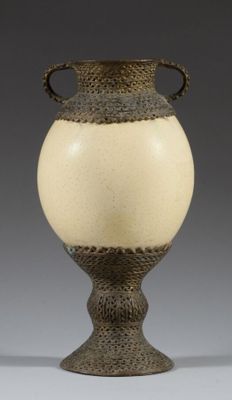 a vase that is sitting on a stand on a table