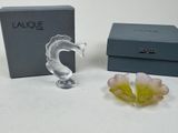a glass figurine with a flower in front of a box