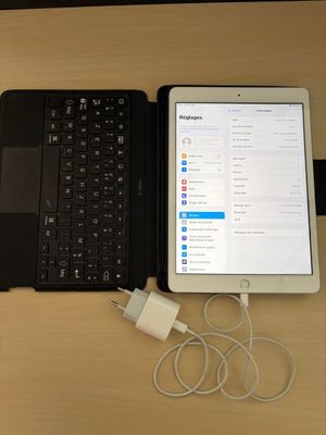 un ordinateur portable et une tablette posés sur une table, avec un chargeur