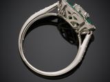 a close up of a ring with a green stone on it