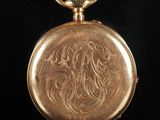 an antique gold pocket watch with a lion design on it