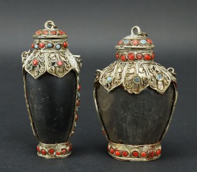 paire de vases noirs et dorés ornés de pierres rouges et bleues