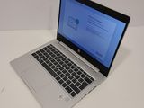 the laptop is open on a white table with a blue screen