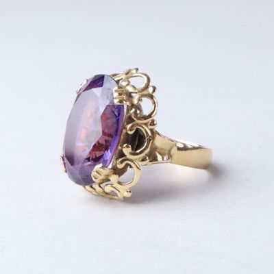 an image of a gold ring with a large amethorate stone
