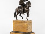 statue of a man on a horse with a gun on a marble base