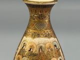 a gold vase with a picture of people on it