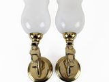 a pair of brass wall lights with frosted glass shades