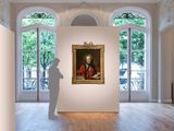 a man standing in a room with a painting on the wall