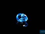 a close up of a blue diamond on a black surface