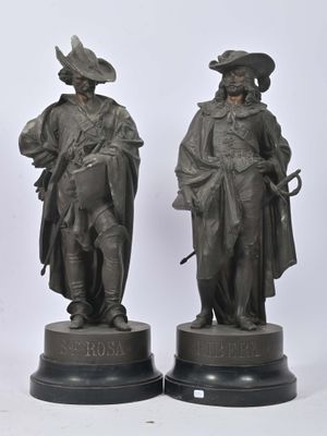 une paire de statues en bronze représentant un homme et une femme vêtus de costumes d'époque