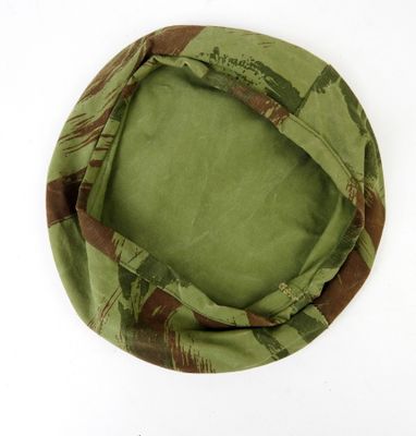 un gros plan d'un chapeau vert et marron posé sur une surface blanche