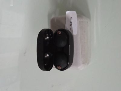 un gros plan sur une paire d'écouteurs noirs posés sur une surface blanche