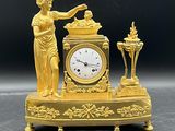 une horloge en or surmontée d'une statue
