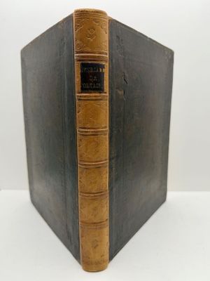 un vieux livre posé sur une table blanche à côté d'un mur blanc