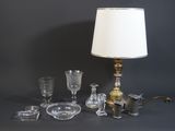 une table sur laquelle se trouvent une lampe, des verres et d'autres objets