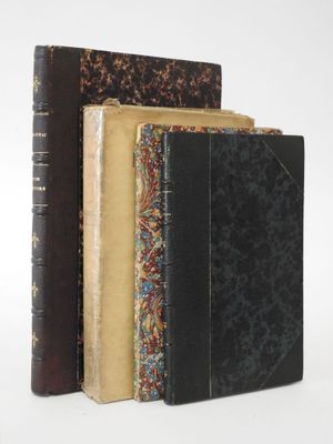 three old books are stacked on top of each other on a white surface