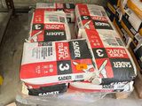 de nombreux sacs de ciment posés sur une palette dans le garage