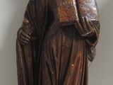 une statue représentant une femme tenant un livre et un chien