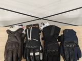 cinq paires de gants en cuir sont alignées sur une étagère en bois