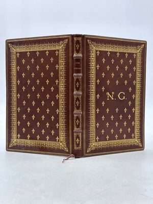 un vieux livre à la couverture dorée et rouge sur un fond blanc