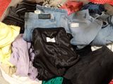 a basket full of clothes that is sitting on the floor