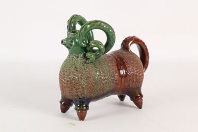 un animal en céramique assis sur une surface blanche