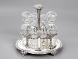 a silver plate with a silver and glass set on it