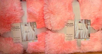 Plusieurs oursons en peluche roses sont exposés dans un magasin