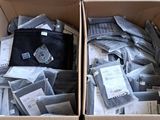 deux cartons remplis de vêtements posés l'un à côté de l'autre sur le sol