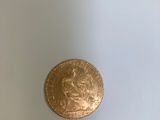 une pièce d'or posée sur une assiette blanche