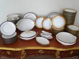 une table sur laquelle se trouvent beaucoup d'assiettes et de bols