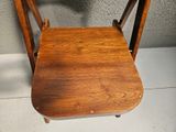 a wooden chair with a wooden seat on a tile floor