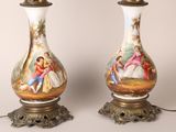 pair of antique porcelain lamps with hand painted scenes on them