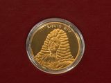 gold coin with a picture of a woman in a hat on it
