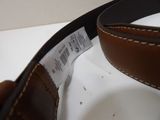 a person holding a leather belt with a label on it
