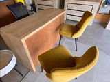 two yellow chairs sitting in front of a desk in a room