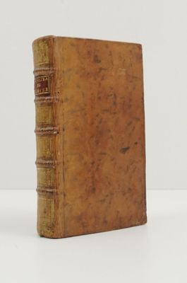 an old book sitting on top of a white table next to a white wall