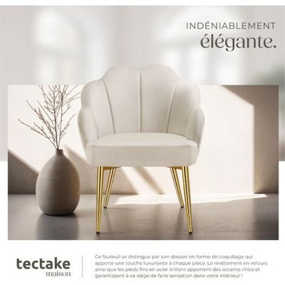 une chaise blanche aux pieds dorés devant un vase