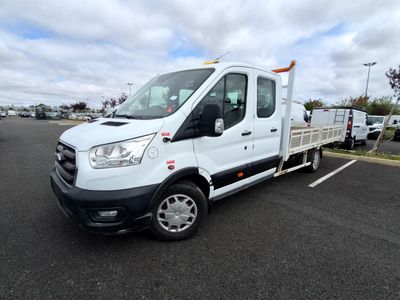 La camionnette blanche est garée sur le parking, à côté d'autres véhicules.