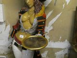 a statue of a woman holding a tray in a room