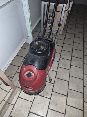 a red and black machine on the floor in a room
