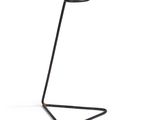 le pied en métal noir soutient une lampe sur un fond blanc