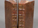 Deux vieux livres sont posés côte à côte sur une surface grise